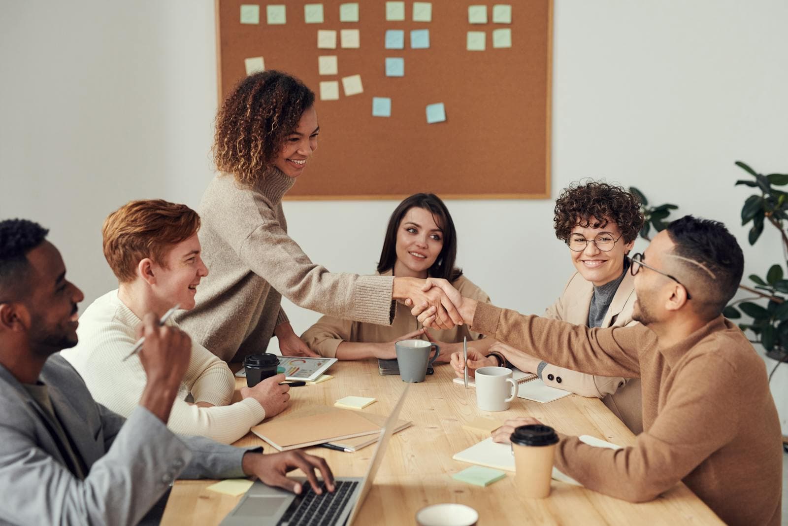 A collaborative business meeting around a table with laptops and notes.