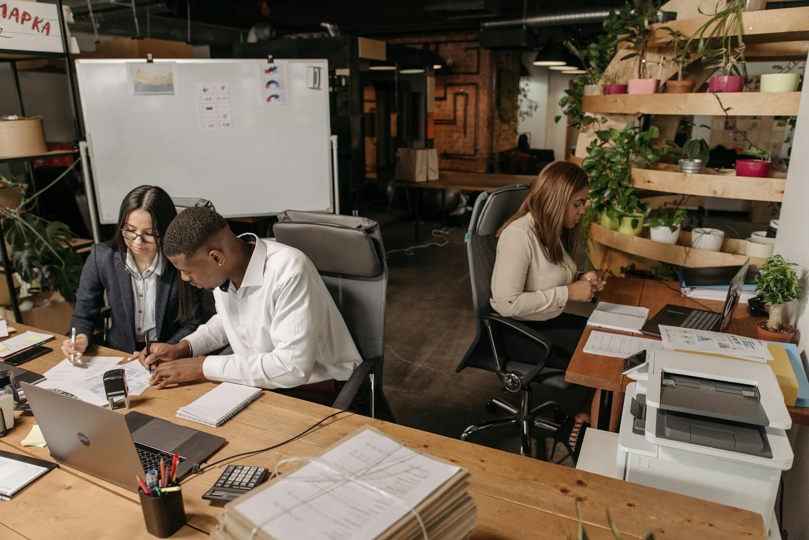 A business owner working at a laptop with analytics and notes nearby.
